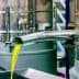 Metal olive oil extraction equipment with oil flowing from a spout into a container. - Olive Oil Times