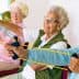 Four senior women using resistance bands for exercise in a seated position. - Olive Oil Times