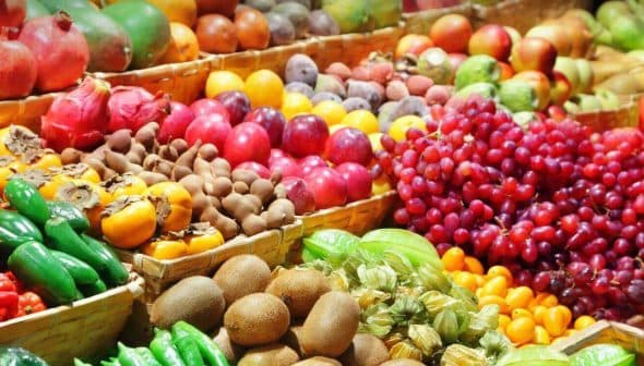 Colorful assortment of fresh fruits and vegetables arranged in baskets at a market. - Olive Oil Times