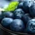 A bowl filled with fresh blueberries and mint leaves on top. - Olive Oil Times