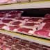 Various packages of red meat displayed on shelves in a supermarket meat section. - Olive Oil Times