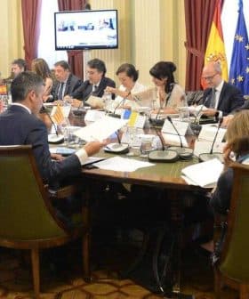 Group of individuals seated around a long table during a meeting in a conference room. - Olive Oil Times