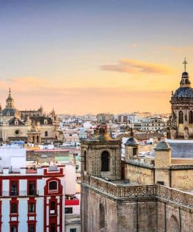 View of Seville's skyline featuring historical buildings and a sunset sky. - Olive Oil Times