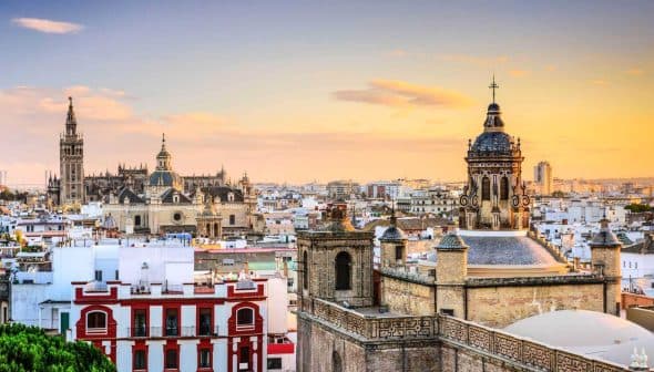 View of Seville's skyline featuring historical buildings and a sunset sky. - Olive Oil Times