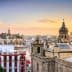 View of Seville's skyline featuring historical buildings and a sunset sky. - Olive Oil Times