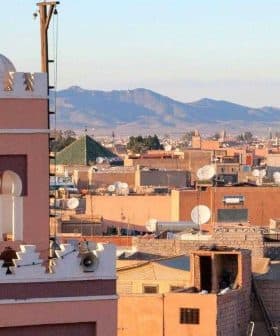 View of Marrakech cityscape featuring a prominent minaret and surrounding buildings under a clear sky. - Olive Oil Times
