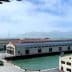 Historic waterfront buildings near the Golden Gate Bridge with water in the foreground and hills in the background. - Olive Oil Times