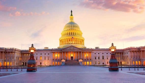 United States Capitol Building illuminated at sunset with a colorful sky in the background. - Olive Oil Times