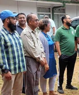 A group of diverse individuals standing together outdoors, wearing casual clothing and engaged in conversation. - Olive Oil Times