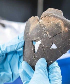 A person holding a fragment of a Celtic ceramic artifact with distinct shapes and textures. - Olive Oil Times