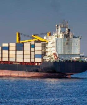 Large container ship with stacked cargo containers sailing in open water. - Olive Oil Times