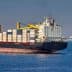 Large container ship with stacked cargo containers sailing in open water. - Olive Oil Times
