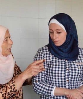 Four women in a kitchen discussing while wearing various head coverings and attire. - Olive Oil Times