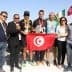 Group photo of Sfax Marathon winners holding a trophy and a Tunisian flag with event organizers. - Olive Oil Times