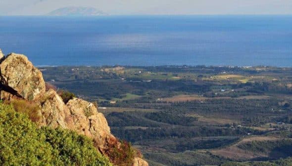 Panoramic view of the coastline and distant island from a rocky outcrop. - Olive Oil Times