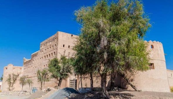 A historic fortification structure with trees in the foreground against a clear blue sky. - Olive Oil Times
