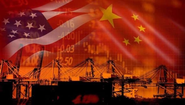 Overlay of the United States and China flags with shipping cranes and stock market graphics in the background. - Olive Oil Times