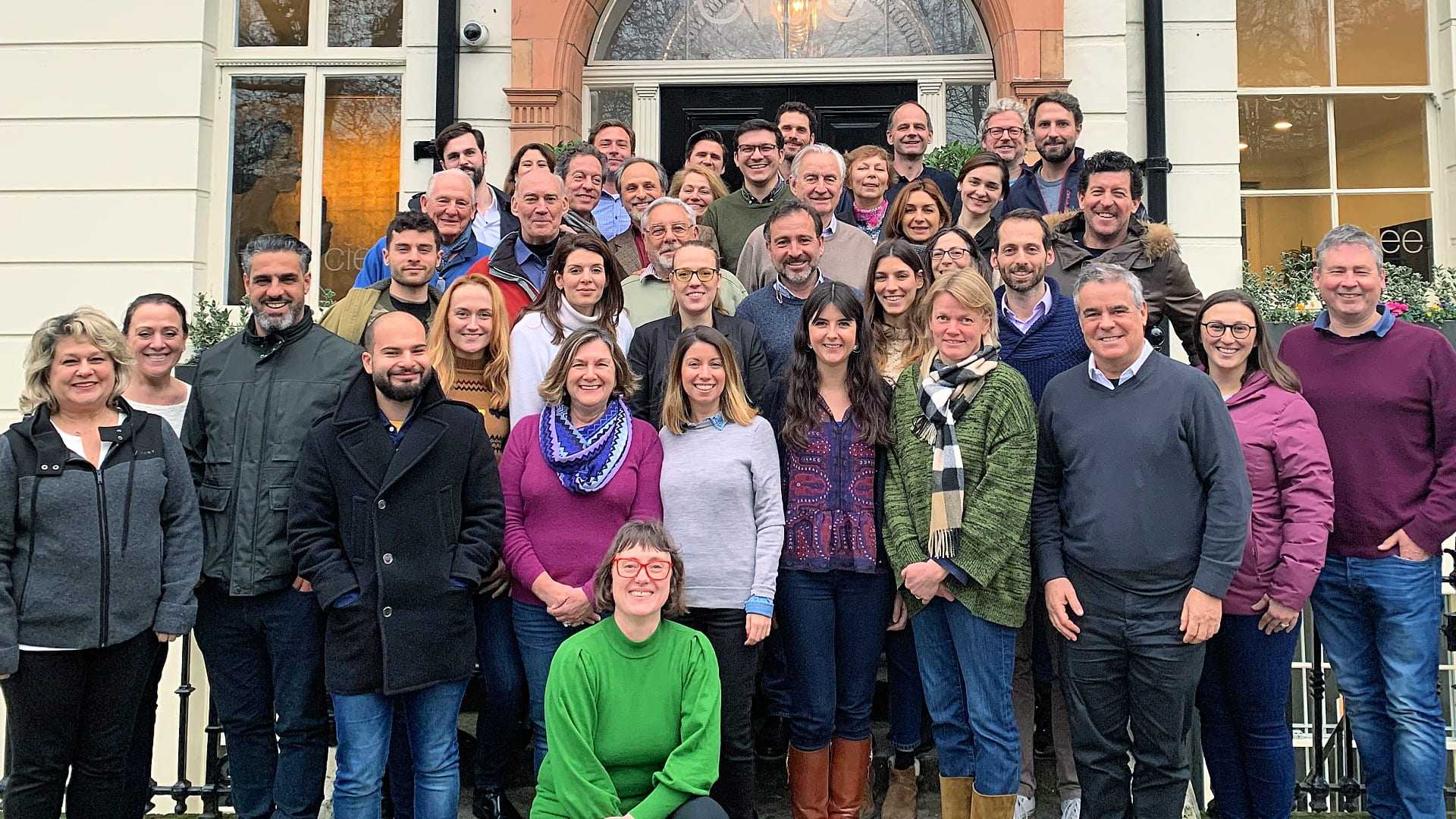 A large group of people posing together for a photo outside a building. - Olive Oil Times