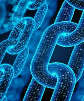 Close-up of digital chain links composed of binary code in a blue color scheme. - Olive Oil Times