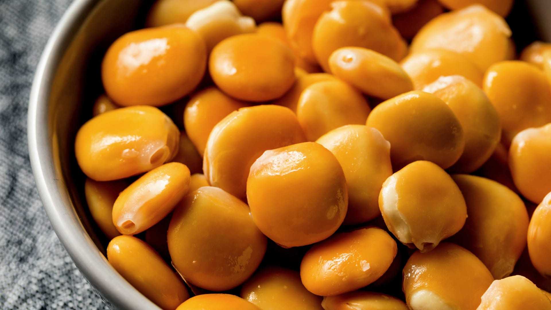 A bowl filled with yellow split peas, showcasing their smooth and shiny surface. - Olive Oil Times