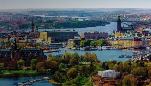 Aerial view of Stockholm showcasing the cityscape, waterways, and greenery in the foreground. - Olive Oil Times