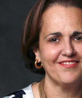 Portrait of a woman with short brown hair wearing hoop earrings and a striped top. - Olive Oil Times