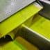 Green olive oil flowing from a metal spout during the extraction process. - Olive Oil Times