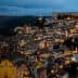 Aerial view of a historic Italian town illuminated at night with buildings and streets visible. - Olive Oil Times