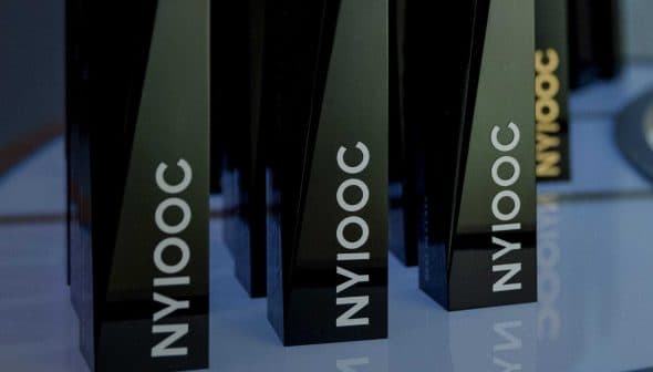 Black trophies with the inscription 'NYIOOC' displayed on a shelf. - Olive Oil Times