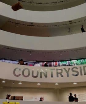 Interior view of a multi-level exhibition space with a large 'COUNTRYSIDE?' sign and visitors on different levels. - Olive Oil Times