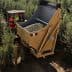 Tractor with a large trailer filled with olives in an olive grove. - Olive Oil Times