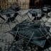 Several black metal tables and chairs stacked on a cobblestone surface. - Olive Oil Times