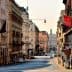 View of a wide, empty street in Rome with buildings lining both sides and traffic signals visible. - Olive Oil Times
