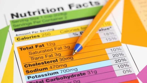 Nutrition facts label with details on calories, fat, sodium, and carbohydrates next to a blue pen. - Olive Oil Times