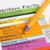 Nutrition facts label with details on calories, fat, sodium, and carbohydrates next to a blue pen. - Olive Oil Times