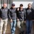 Six men standing in a row wearing gray hoodies with 'TRE Olive' printed on them. - Olive Oil Times