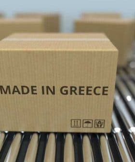 Cardboard box labeled 'Made in Greece' on a conveyor belt among other boxes. - Olive Oil Times