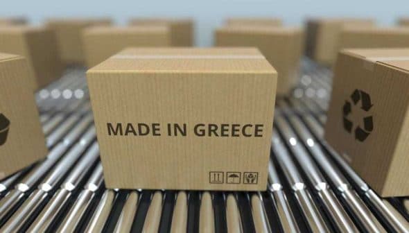 Cardboard box labeled 'Made in Greece' on a conveyor belt among other boxes. - Olive Oil Times