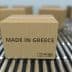 Cardboard box labeled 'Made in Greece' on a conveyor belt among other boxes. - Olive Oil Times