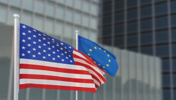 United States flag and European Union flag waving side by side on flagpoles. - Olive Oil Times