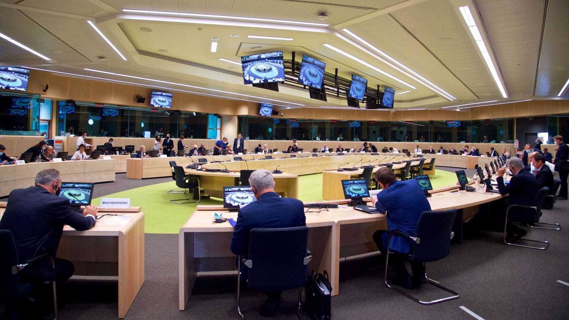 A large conference room with multiple tables and participants engaged in a meeting. - Olive Oil Times