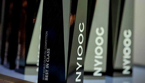 Trophies from the 2019 World Olive Oil Competition labeled 'Best in Class' and 'NYIOOC'. - Olive Oil Times