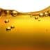 Close-up image of olive oil with bubbles suspended in the liquid. - Olive Oil Times