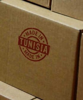 Stack of cardboard boxes featuring a red 'Made in Tunisia' stamp on the side. - Olive Oil Times