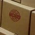 Stack of cardboard boxes featuring a red 'Made in Tunisia' stamp on the side. - Olive Oil Times