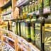 Various bottles of olive oil displayed on a shelf in a grocery store. - Olive Oil Times