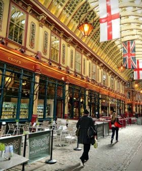 Interior view of a historic market featuring flags and people walking through. - Olive Oil Times