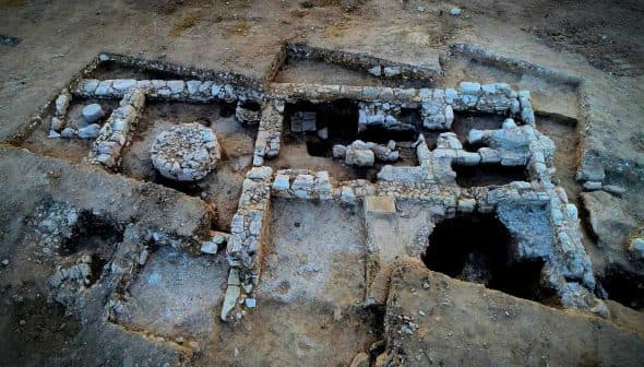 Aerial view of an archaeological site featuring stone structures and excavated areas. - Olive Oil Times