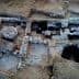 Aerial view of an archaeological site featuring stone structures and excavated areas. - Olive Oil Times