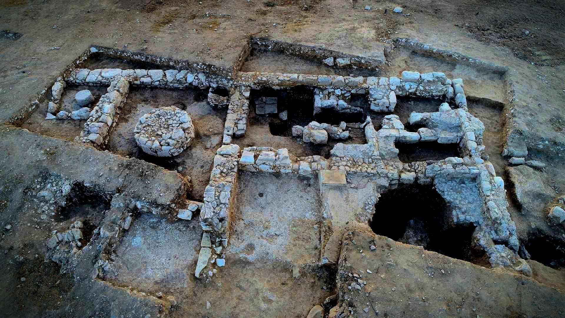 Aerial view of an archaeological site featuring stone structures and excavated areas. - Olive Oil Times